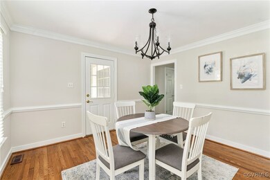 The dining room features hardwood flooring, a chan
