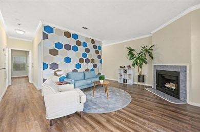 Living room with crown molding, wood finished flo