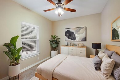 Bedroom with tile patterned floors and a ceiling fan