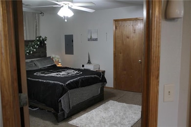 Bedroom with electric panel, carpet flooring, and ceiling fan