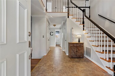 Spacious tiled foyer with detailed moldings
