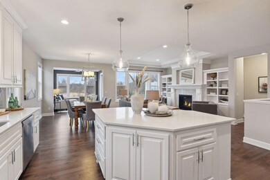 The kitchen features enameled cabinetry with quartz countertops and designer lighting.