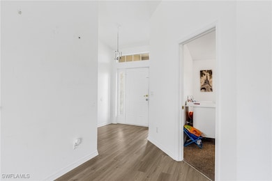 Entrance foyer with wood finished floors, baseboar