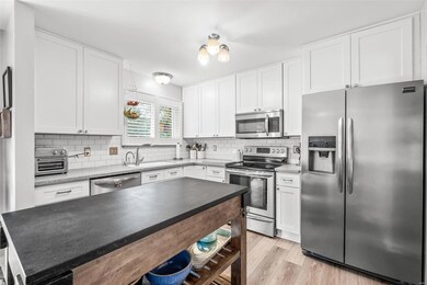 White cabinets to ceiling, updated light fixtures, white subway tile backsplash, SS appliances.