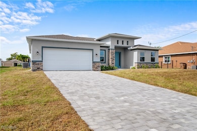 Prairie-style house featuring stone siding, a front yard, stucco siding, and decorative driveway