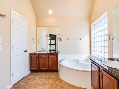 Bathroom with vaulted ceiling, a whirlpool tub, t