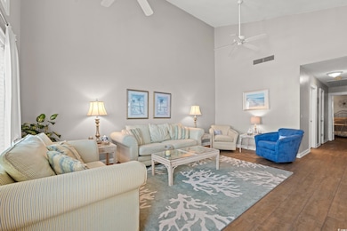 Living room featuring a ceiling fan, high vaulted ceiling, and wood-type flooring