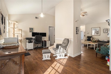 Home office with dark wood finished floors, high vaulted ceiling, and ceiling fan