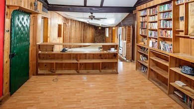 Bathroom with wooden walls, light wood finished floors, and ceiling fan