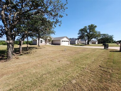 View of yard featuring concrete driveway and a gar