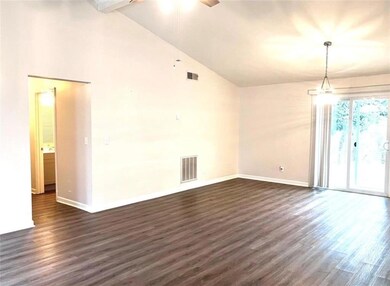 Unfurnished room featuring dark wood-type flooring, a ceiling fan, and high vaulted ceiling
