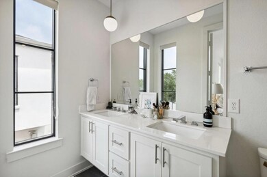 Bathroom with toilet and dual bowl vanity