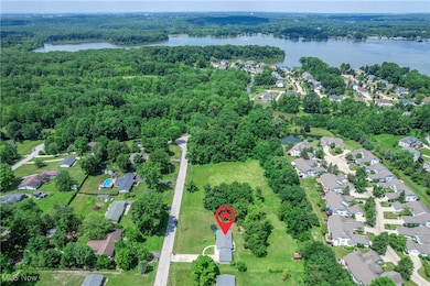 Aerial view of property's location featuring a nearby body of water and nearby suburban area
