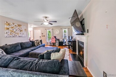 Living room with dark wood finished floors, a fire