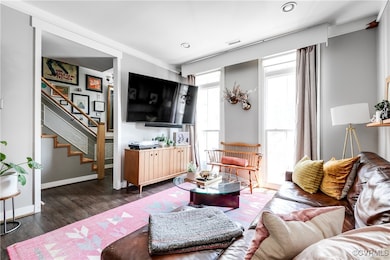 Living area with wood finished floors, stairway, a