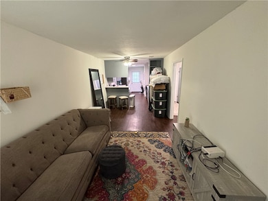 Living room with ceiling fan and dark wood-style f