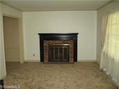 Den/Family/Great Room. This is a very large den with a wooden fireplace.  Very nice window in front.  The carpet has hardwood floors under it.