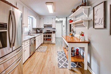 Kitchen - granite countertops, farmhouse sink, floating shelves, pantry and closet in foyer area by kitchen.