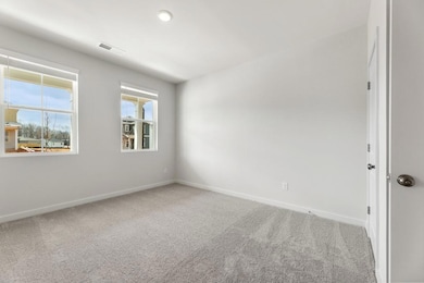 Carpeted spare room featuring baseboards