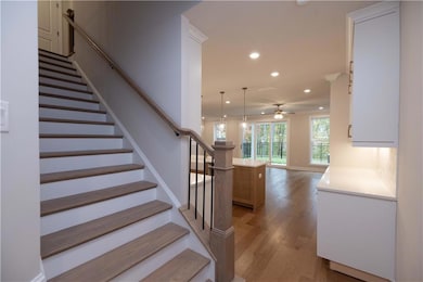 Stairs with baseboards, wood finished floors, a ce