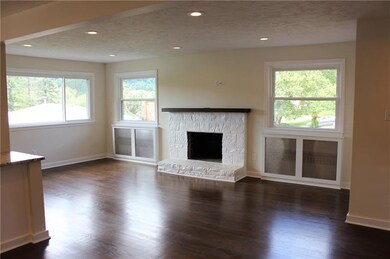Living room features hardwoods and a fireplace