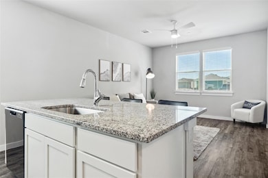 Kitchen with a sink, dark wood-type flooring, sta