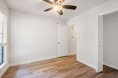Unfurnished bedroom with wood finished floors, ba