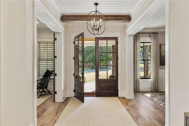 Welcoming entry is bathed in sunlight and accented with wood beams and millwork. All wall corners are rounded, enhancing this home's architectural appeal