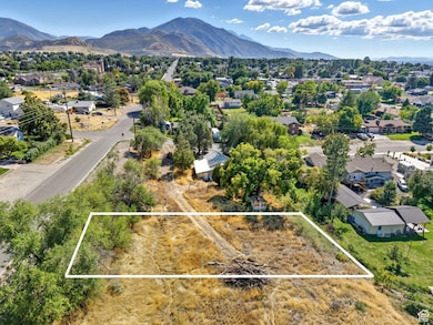 Aerial perspective of suburban area featuring a mountainous background and property boundaries highlighted