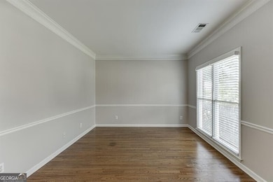 Unfurnished room with dark wood-type flooring and ornamental molding