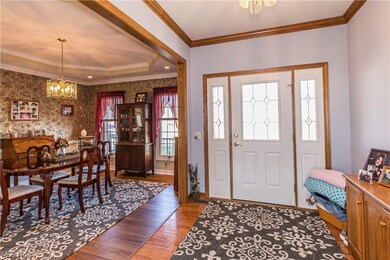 Entryway with light hardwood / wood-style floors, a notable chandelier, and crown molding