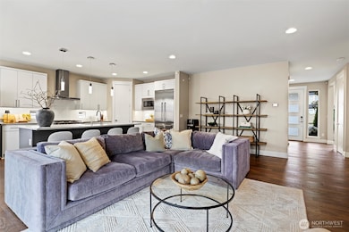 Large great room with high ceilings and grand chef's kitchen. Gas Fireplace, custom mounted TV, floor to ceiling tile surround.