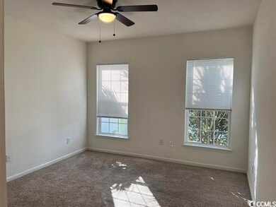 Carpeted spare room featuring ceiling fan