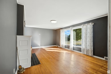 Living room with wood flooring and large east-facing windows.