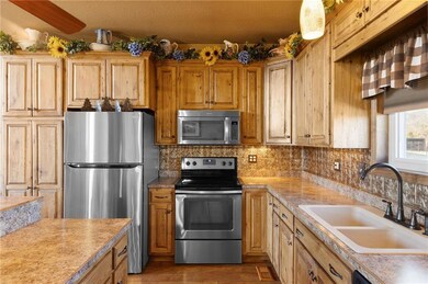 Kitchen featuring backsplash, stainless steel appliances, light countertops, and a sink