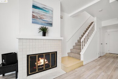 Unfurnished living room with wood finished floors, stairs, and a fireplace