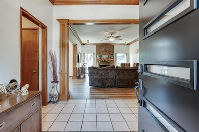 Foyer featuring ornamental molding, ceiling fan, and light tile patterned floors