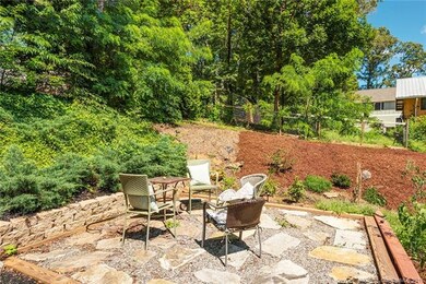 Tiered and trellised back yard includes stone and gravel patio area in the back yard.