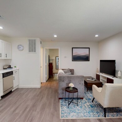 Living room with light wood finished floors and recessed lighting