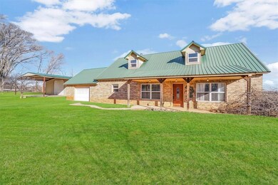 Rear view of property with a yard and a garage