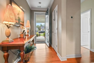 Entryway with ornamental molding and wood-type flooring