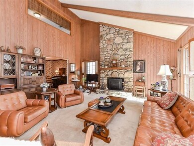 Large great room with carpet and bright windows.