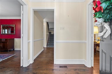 Corridor with crown molding and dark wood-type flo
