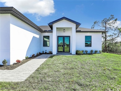 View of exterior entry featuring a yard and french