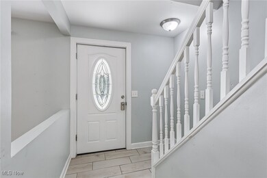 Foyer entrance with stairway and baseboards