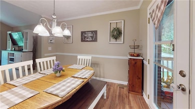 Dining room featuring a chandelier, wood finished floors, and ornamental molding