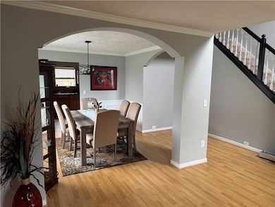 Dining space featuring arched walkways, light wood