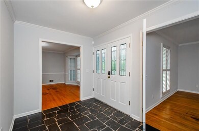 Entrance foyer with ornamental molding, baseboards, and dark stone finish flooring