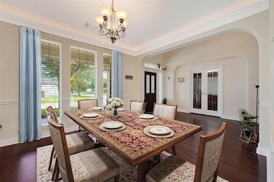 Formal dining area with wood flooring and crown mo