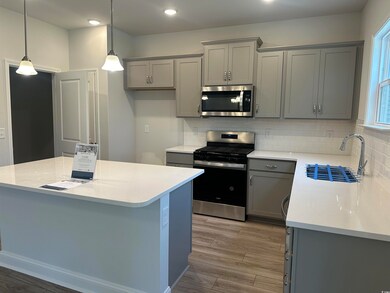 Kitchen with pendant lighting, sink, gray cabinetr